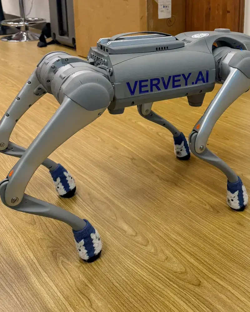 Q-Series four-legged robot walking on a wooden floor